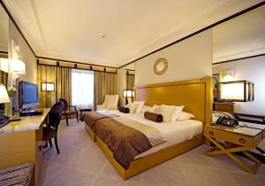 a hotel room with a large bed and a desk at Grande Real Villa Itália Hotel & Spa in Cascais