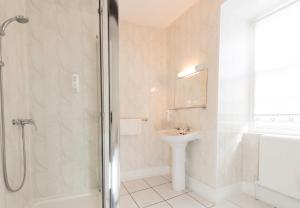 a bathroom with a shower and a sink and a toilet at The Beaufort Hotel in Chepstow +27 photos