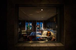 a reflection of a room with a bed in a mirror at HUUS Gstaad in Gstaad