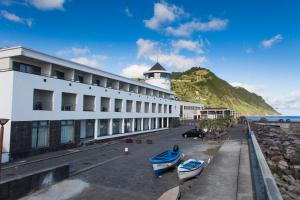 a building with two boats parked in front of it at Hotel do Mar in Povoação