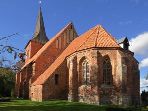 an old brick church with a steeple on the grass at Ferienhaus Luise in Lüdershagen