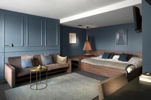 a bedroom with a bed and a couch at COMMUNE suites in Amsterdam