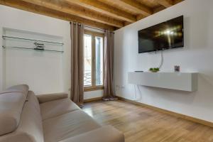 sala de estar con sofá y TV en la pared en Appartamento Arco en Padova