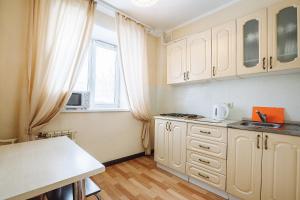 a kitchen with white cabinets and a window at Апартаменты Авион Комфорт in Kemerovo