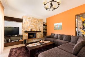 a living room with a couch and a fireplace at Villa Leyland in Faliraki