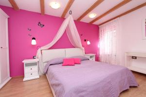 różowa sypialnia z łóżkiem z baldachimem w obiekcie Apartment Midea w Rovinj