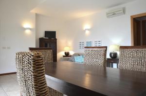 a dining room with a wooden table and chairs at Sa Tirìa in Chia