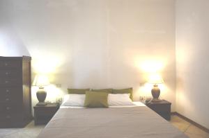 a bedroom with a large bed with two lamps at Sa Tirìa in Chia