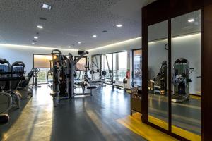 a gym with several tread machines in a room at Paraíso Villas & Spa in Guimarães