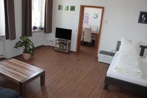 ein Wohnzimmer mit einem Bett und einem TV in der Unterkunft Thai Tawan in Rheinhausen