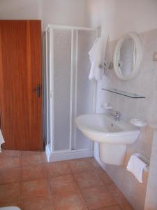y baño blanco con lavabo y ducha. en Albergo Il Brillantino, en San Nicola Arcella
