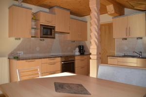 a kitchen with wooden cabinets and a wooden table at Pension Dürregger in Flattach
