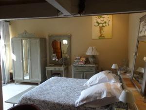 1 dormitorio con cama y espejo en Chambre d'hôte Anais, en Eyguières