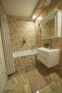 un baño con lavabo y bañera en Apartment Atlantis, en Járkov 5 fotos más