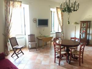 sala de estar con mesa, sillas y TV en Casa Romantica, en Tuscania