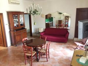 sala de estar con sofá rojo y mesa en Casa Romantica, en Tuscania
