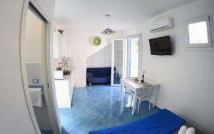 サン・ヴィート・ロ・カーポにあるAppartamento Martinaの青いタイルフロアの客室で、テーブルが備わります。
