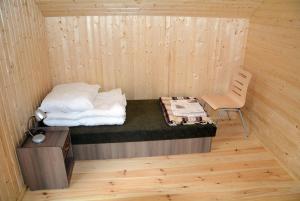 ein kleines Zimmer mit einem Bett und einem Stuhl in der Unterkunft OTW Płotki in Piła