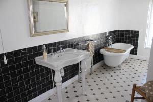 a bathroom with a sink and a tub and a toilet at The Olde House in Dunster