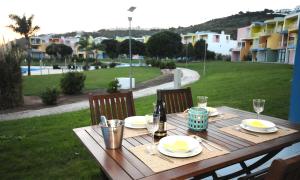 a wooden table with plates and a bottle of wine at AlgarveFlat in Albufeira