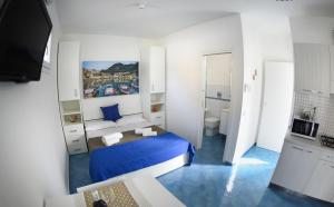 a small room with a blue bed and a bathroom at Appartamento Martina in San Vito lo Capo