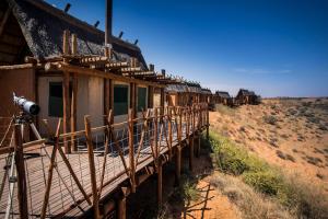 a row of houses in the middle of the desert at Xaus Lodge in Twee Rivieren +27 photos