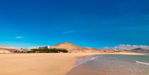 a view of a beach with a building in the background at INNSiDE by Meliá Fuerteventura – Adults Only in Costa Calma