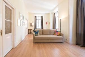 uma sala de estar com um sofá num piso de madeira em Assuncao Apartment em Lisboa