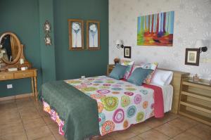 ein Schlafzimmer mit einem Bett mit einer bunten Bettdecke in der Unterkunft Pedro's house with fantastic views in Telde