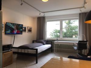 a bedroom with a bed and a tv on the wall at Quiet Oasis Universities/Arts District in Munich