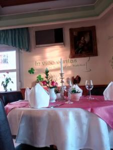 a table with a pink table cloth and wine glasses at Adler Golf-& Tagungshotel in Harth - Pöllnitz