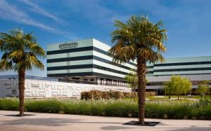 
a large palm tree stands in front of a large building at Pullman Bordeaux Lac in Bordeaux
