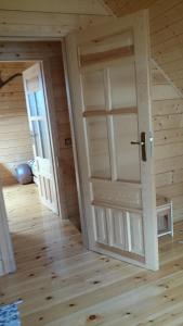 an empty room with a door in a cabin at Letniskowy domek z bala w Mikołajkach in Mikołajki