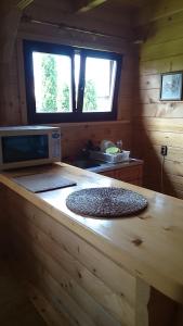 a kitchen with a wooden counter top with a microwave at Letniskowy domek z bala w Mikołajkach in Mikołajki