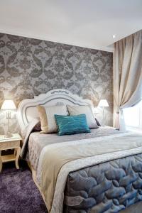 um quarto com uma cama grande e uma almofada azul em Grand Hotel des Terreaux em Lyon