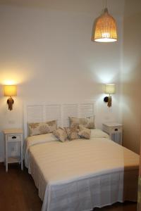 um quarto com uma grande cama branca e duas mesas em Affittacamere I Gatti delle 5 Terre em La Spezia