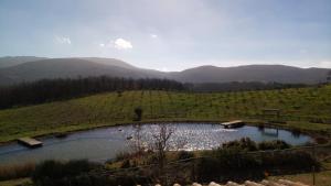 un estanque en un campo con montañas al fondo en Fattoria San Paolo Agriturismo en Montecastelli Pisano