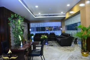a lobby with couches and a table and chairs at Hotel Sonar Tori in Agartala
