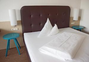 a bedroom with a bed with two blue stools at Landgasthof Bogner in Absam