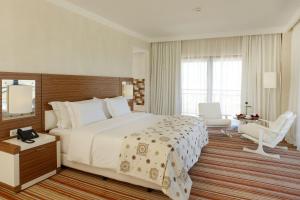 a hotel room with a large bed and a chair at Real Marina Hotel & Spa in Olhão