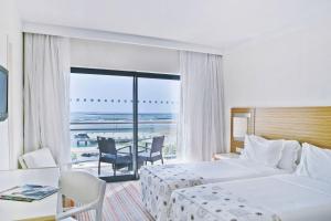 a hotel room with a bed and a view of the ocean at Real Marina Hotel & Spa in Olhão