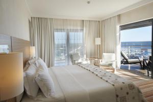 a hotel room with a large bed and a balcony at Real Marina Hotel & Spa in Olhão