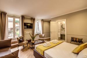 ローマにあるCharme Spagna Boutique Hotelのベッドとリビングルームが備わるホテルルームです。