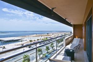 a balcony with a view of the beach and the ocean at Real Marina Hotel & Spa in Olhão