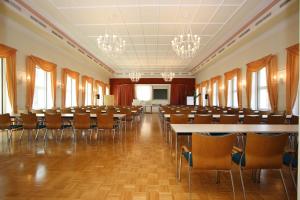 Cette grande chambre comprend des rangées de tables et de chaises. dans l'établissement Akzent Hotel Am Burgholz, à Tabarz
