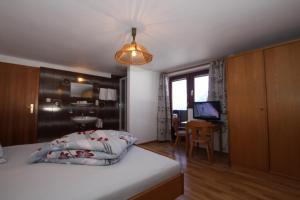 a bedroom with a bed and a desk with a computer at Pfandlhof in Walchsee