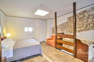 トゥーリにあるAntiche Mura Apartments "Nel Cuore della Puglia"bivani, cucina, terrazzoのベッドルーム1室(ベッド1台、ソファ付)