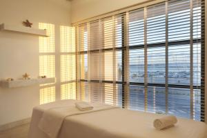 a bedroom with a bed and a large window at Real Marina Hotel & Spa in Olhão