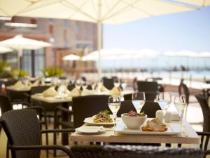 una mesa con platos de comida y copas de vino en Real Marina Hotel & Spa, en Olhão