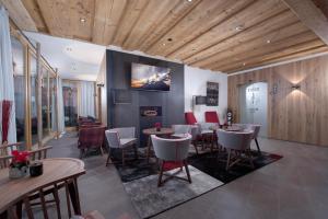 a restaurant with tables and chairs and a tv on the wall at Hotel Fischer in Sankt Johann in Tirol